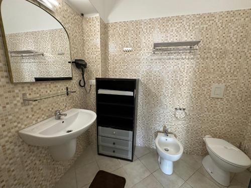 a bathroom with a sink and a toilet and a mirror at CconfortHotels Appartamento Crispi - SELF CHECK IN in Bari