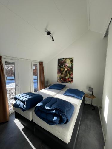 a bedroom with two beds with blue pillows at Camping de Vinkenkamp in Lieren