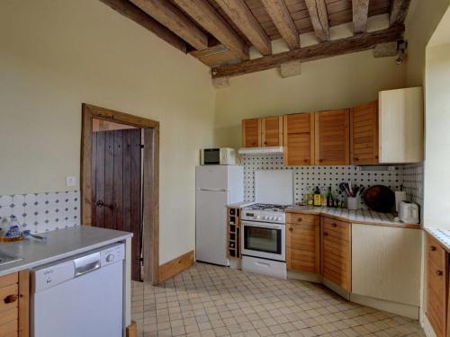 a kitchen with white appliances and wooden cabinets at Mansion in Burgundy near Morvan Natural Park in Moussy