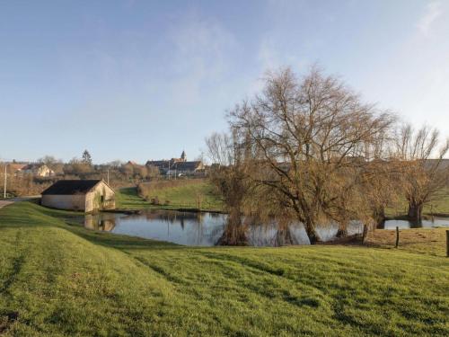 a grassy field next to a river with a barn at Mansion in Burgundy near Morvan Natural Park in Moussy