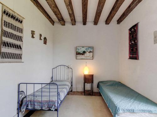 a bedroom with two beds and a table with a lamp at Mansion in Burgundy near Morvan Natural Park in Moussy