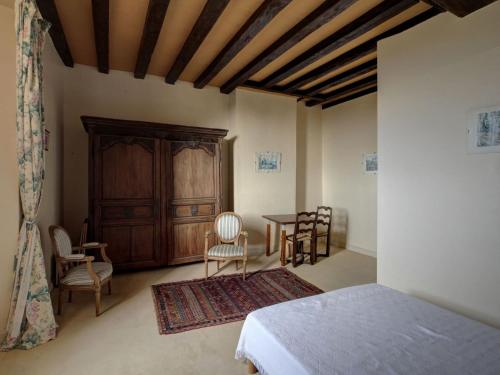 1 dormitorio con 1 cama, mesa y sillas en 17th century manor house in the Niavre, en Moussy