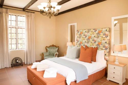 a bedroom with a large bed and a chandelier at Remhoogte Mountain Lodge in Jacksonstuin