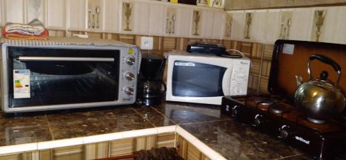 uma cozinha com um micro-ondas e uma torradeira. em TOP Appartement em Aourir