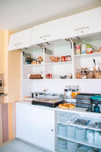 una cocina con armarios blancos y platos en estanterías en Arca Nova Guest House & Hostel Caminha en Caminha