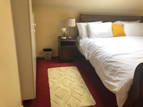 1 dormitorio con 1 cama y 1 mesa con lámpara en Railway Avenue Rooms en Clifden