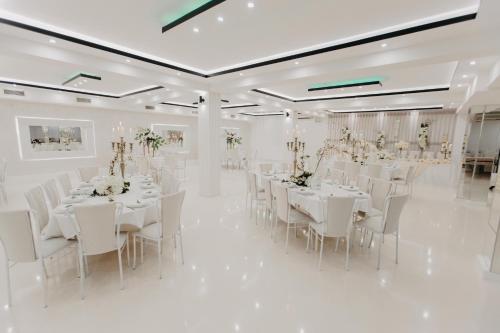 a white banquet hall with white tables and white chairs at Svadbeni salon i prenoćište MILANOVIĆ in Nevesinje