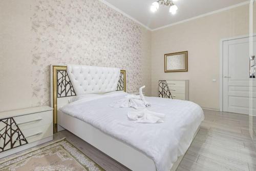 a white bedroom with a large bed with white sheets at Жк Millennium Park, Большие Апартаменты на площади страны in Astana