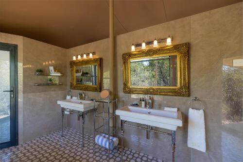 a bathroom with two sinks and a mirror at Oase by 7 Star Lodges - Greater Kruger Private 530ha Reserve in Hoedspruit