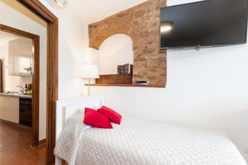 a bedroom with a white bed with red pillows at Smeraldo in Spello