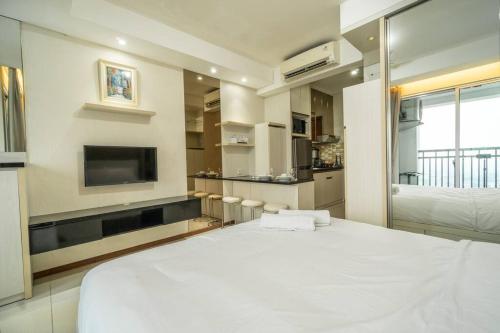 a bedroom with a large white bed and a tv at Modern & comfy studio in central Jakarta, SCBD in Jakarta