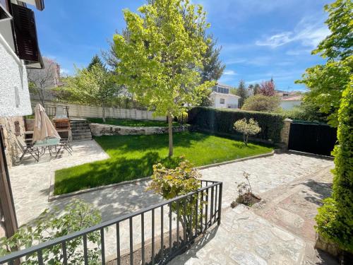 a garden with a tree and a fence at La Fontanilla en Estación de El Espinar in Segovia