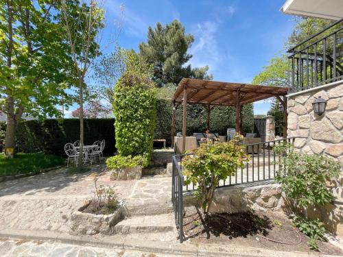 a patio with a wooden pergola and a table at La Fontanilla en Estación de El Espinar in Segovia