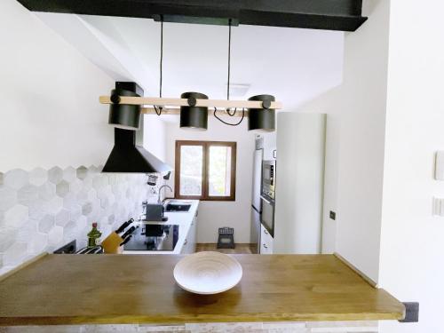 a kitchen with white walls and a wooden table at La Fontanilla en Estación de El Espinar in Segovia