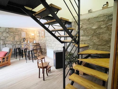 a staircase in a room with a table and chairs at La Fontanilla en Estación de El Espinar in Segovia
