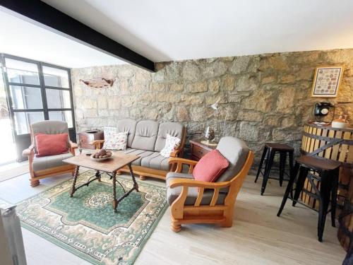 a living room with a stone wall at La Fontanilla en Estación de El Espinar in Segovia