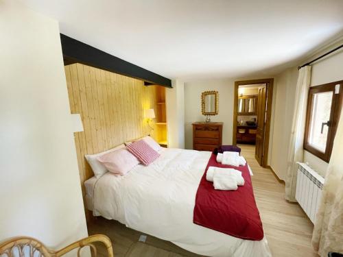 1 dormitorio con 1 cama grande y toallas. en La Fontanilla en Estación de El Espinar, en Segovia