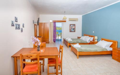 a living room with two beds and a table and chairs at Zenstay Hotel in Áyios Nikólaos Nirás