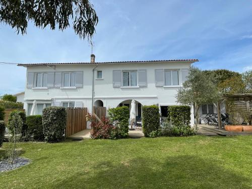 a white house with a fence and a yard at Vacances Sur Mer in Saint-Palais-sur-Mer