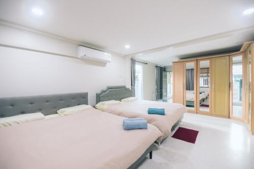 a bedroom with two beds and a large window at Paradise Found 4BR Villa,Fits 22 PAX, 6-Min to Lee Garden in Hat Yai