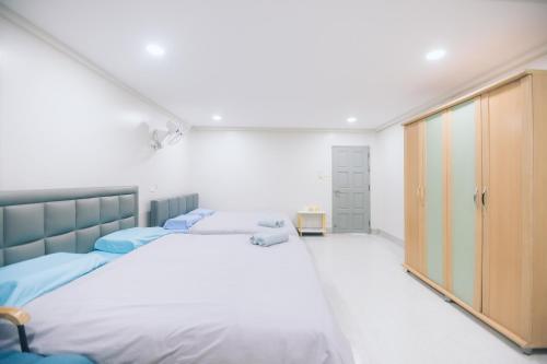 a bedroom with two beds and a closet at Paradise Found - Hat Yai 292sqm Family Home in Hat Yai