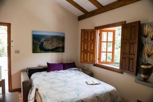 1 dormitorio con 1 cama y 2 ventanas en El balcón de la Penela, en Belesar