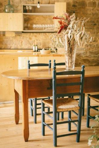 una mesa de madera con sillas y un jarrón de flores en inLoft Copons en Copóns