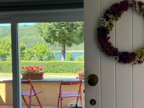 a porch with two chairs and a wreath on the door at Casa d´Água in Venda Nova
