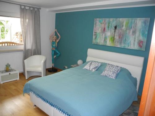 una camera blu con un letto e una sedia di FEWO Mariposa a Riegelsberg