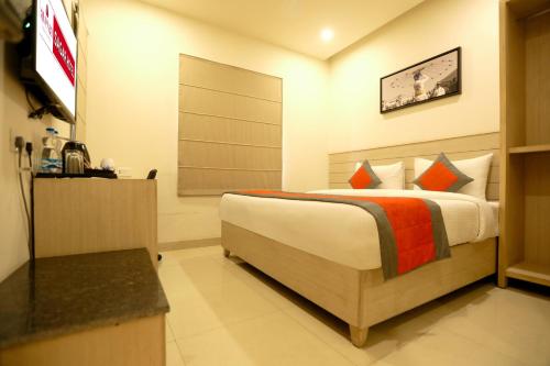 a bedroom with a bed and a television in it at Perfect Plus just 5 mins walk to Golden Temple in Amritsar