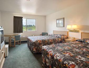 a hotel room with two beds and a television at Northwoods Inn and Suites in Ely