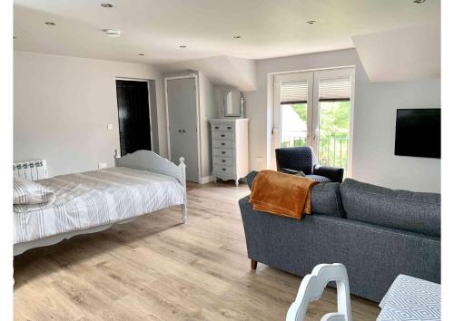 sala de estar con sofá y cama en Acorn Attic, a modern, new first floor garden annex, en Great Ouseburn
