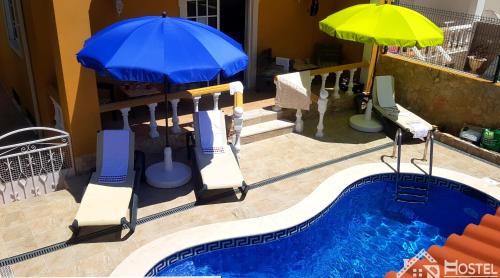 Vila with Private Pool في فيلا ريال دي سانتو انطونيو: مسبح مع مظلتين وكراسي ومسبح