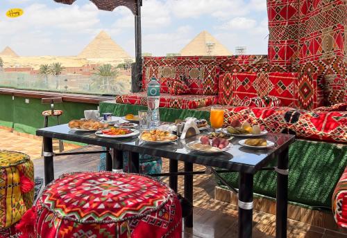 einen Tisch mit Teller Essen auf einem Raum mit Pyramiden in der Unterkunft Happy View Inn in Kairo
