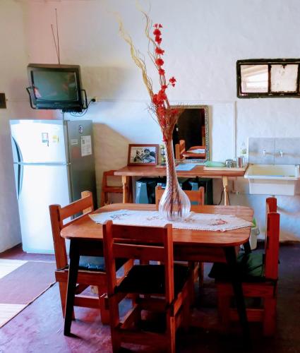 a kitchen with a table with a vase of flowers on it at Casargentina Apart Depto entero Baño privado 15min Ezeiza in Monte Grande