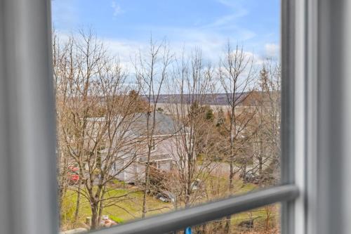 a window with a view of trees and a field at INITIAL - HORIZON - Chutes-Montmorency in Boischâtel