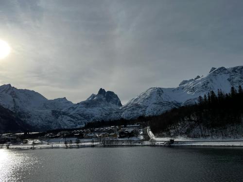 a body of water with snow covered mountains in the background at Frichs Ekspress Åndalsnes in Åndalsnes