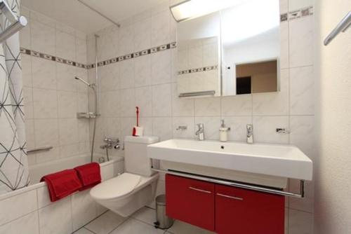 a bathroom with a sink and a toilet and a tub at Tgesa La Niva 11 in Savognin