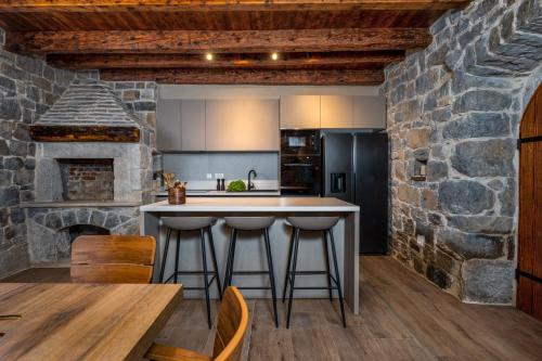 a kitchen with a stone fireplace and a table and chairs at New! Charming Villa Perina with private heated pool in Tugare