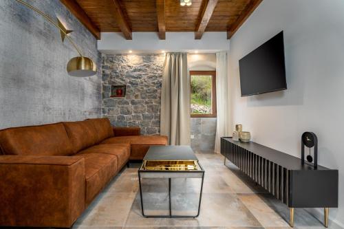 a living room with a brown couch and a table at New! Charming Villa Perina with private heated pool in Tugare