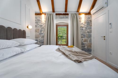 a bedroom with a large white bed and a window at New! Charming Villa Perina with private heated pool in Tugare