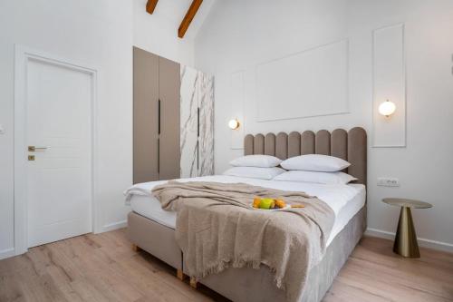 a bedroom with a bed with a bowl of fruit on it at New! Charming Villa Perina with private heated pool in Tugare