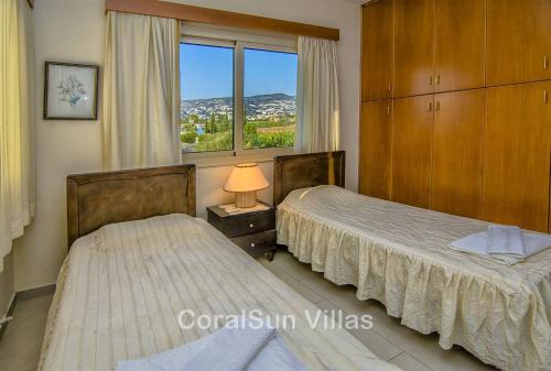 Dos camas en una habitación con ventana. en Amazing Pool, Complete Privacy, Amenities and Beach nearby, en Peyia