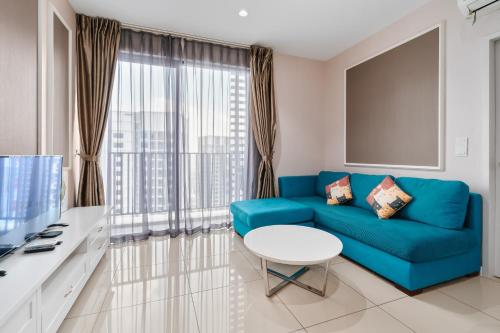 a living room with a blue couch and a table at HostaHome Suites at I-City, Central Mall in Shah Alam