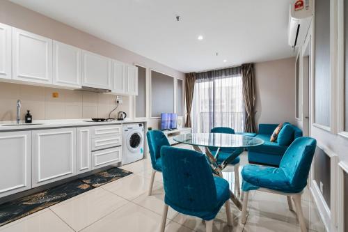 a kitchen with a glass table and blue chairs at HostaHome Suites at I-City, Central Mall in Shah Alam