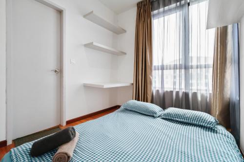a bedroom with a blue bed with a window at HostaHome Suites at I-City, Central Mall in Shah Alam