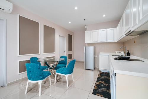 a kitchen with a glass table and blue chairs at HostaHome Suites at I-City, Central Mall in Shah Alam