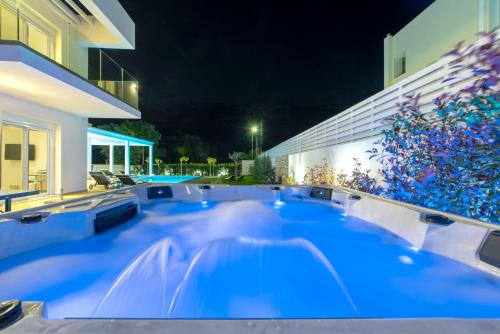 a hot tub in the backyard of a house at night at Villa Myrto in Ialyssos