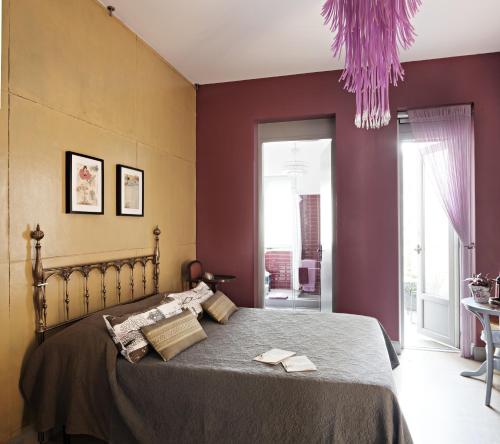a bedroom with a bed with purple walls at Rosso Segnale Milano in Milan