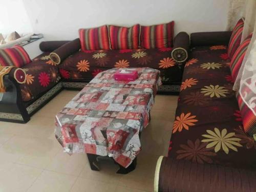 uma sala de estar com um sofá e uma mesa em Appartement en location em Fnideq